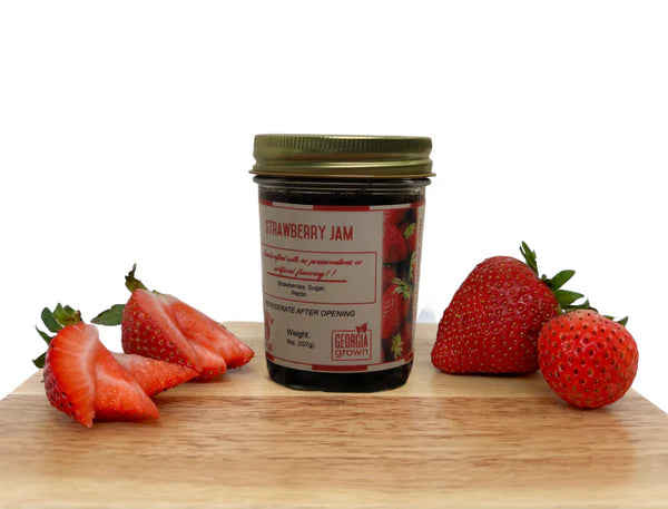 Double L Ranch Strawberry Jam jar on a board with fresh strawberry slices