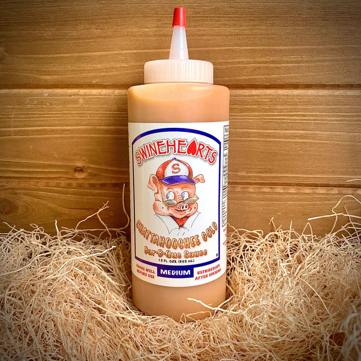 Front view of the Medium Swinehearts Sauce placed on hay with a wooden backdrop