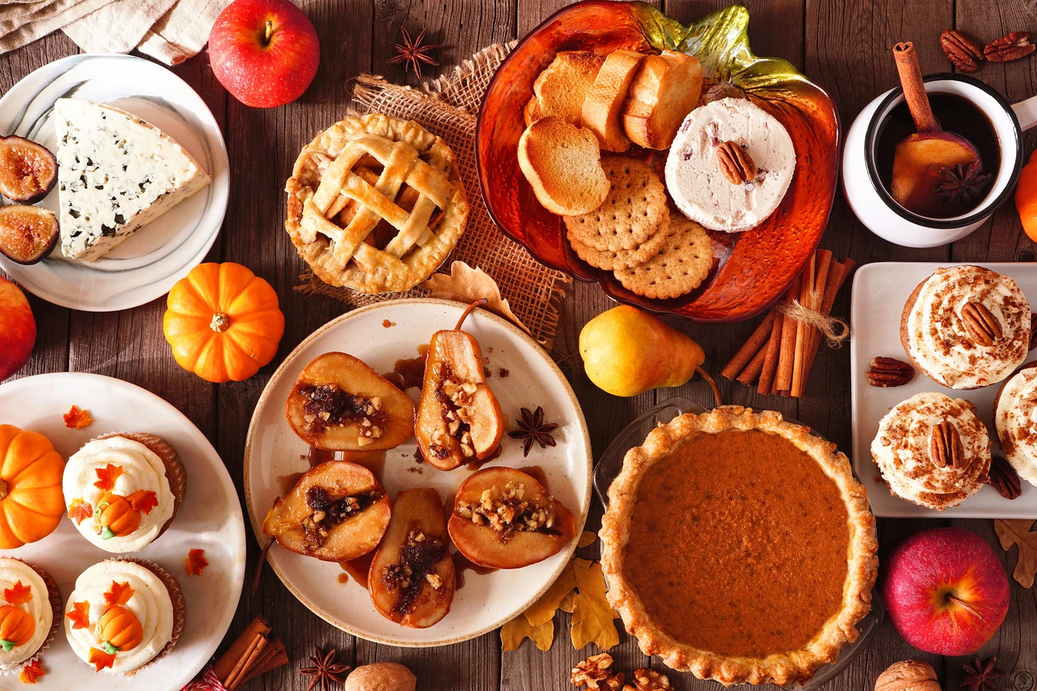 fall food like cupcakes, pies, bread, jams, jellies, pies, and fruit spread out on a table