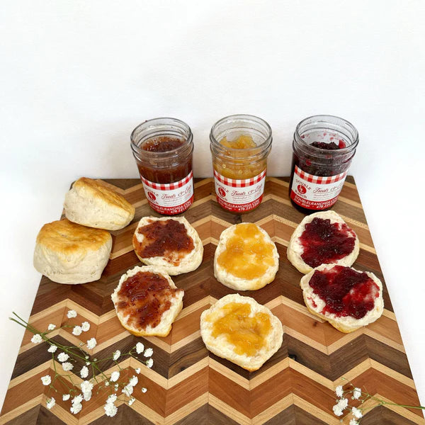 Double L Ranch three preserve jars with biscuit spread on a board